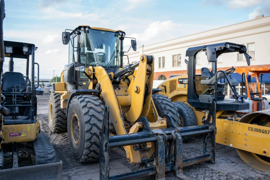Engin de chantier Caterpillar avec une chargeuse et un rouleau compresseur sur un site de construction.