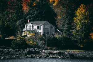 pexels-einfoto-2326931_optimized - RenovSmart Maison individuelle grise entourée d’arbres aux couleurs automnales près d’un plan d’eau en Wallonie.