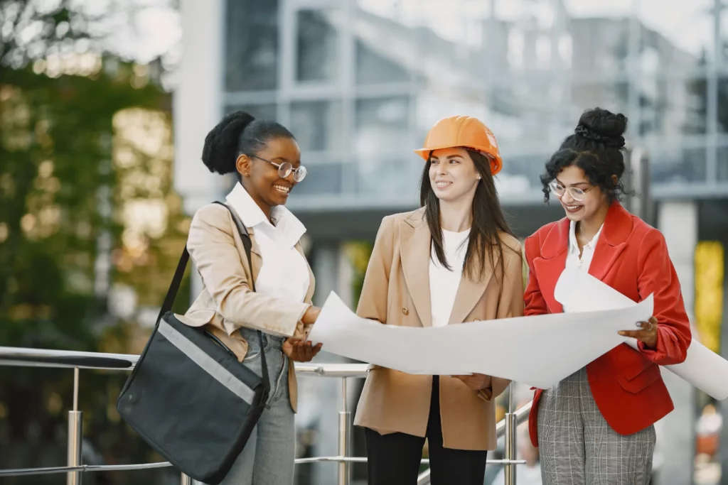 pexels-gustavo-fring-8770080_optimized - RenovSmart Trois femmes professionnelles discutant autour d’un plan architectural, dont une porte un casque de chantier.