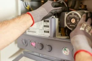 pexels-heiko-ruth-53441229-7859953_optimized - RenovSmart Technicien ajustant une pompe à chaleur avec gants de protection.