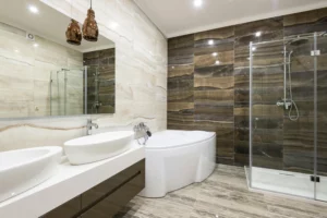 Salle de bain moderne rénovée avec baignoire, douche à l’italienne, double vasque et carrelage aux tons naturels.