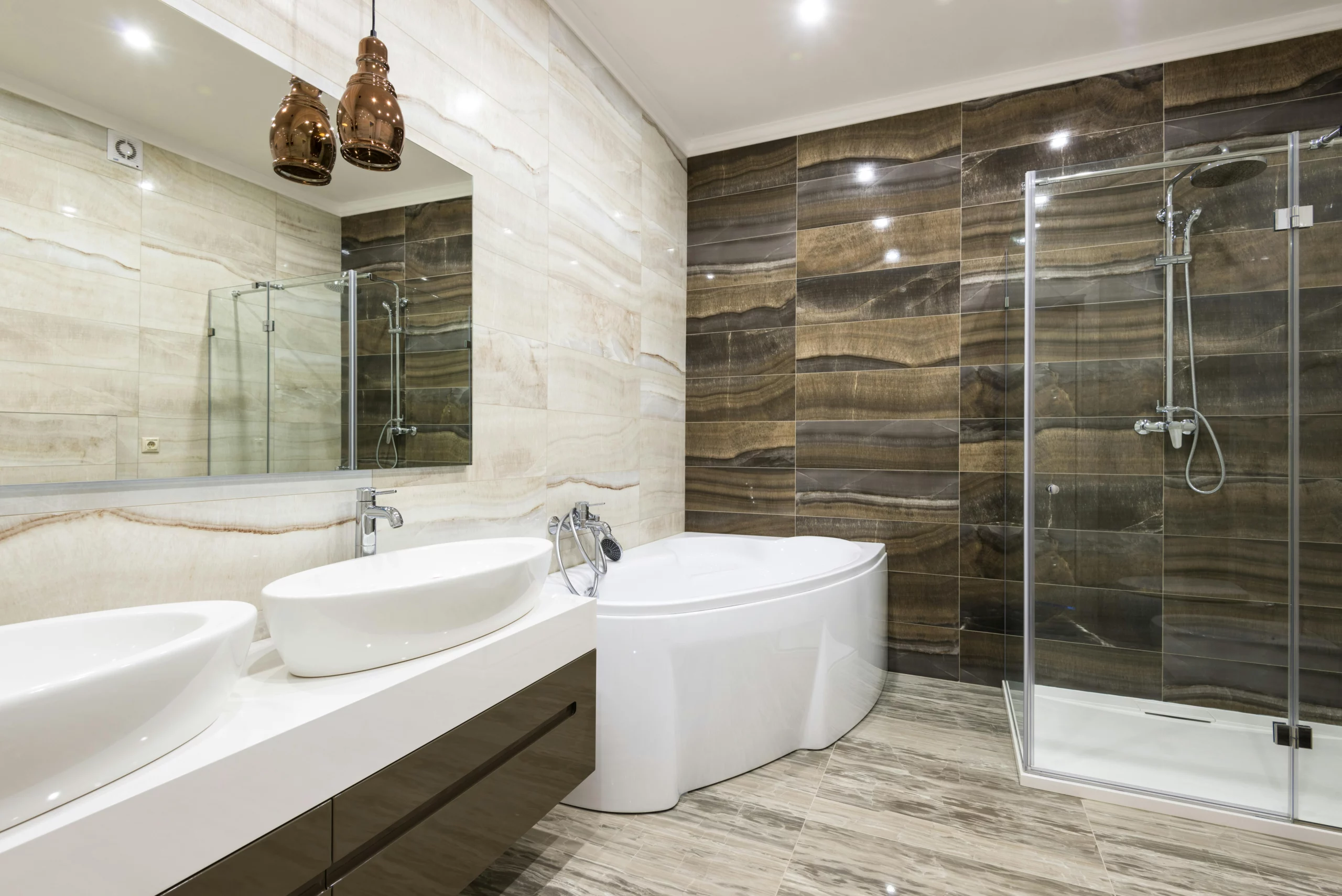 Salle de bain moderne rénovée avec baignoire, douche à l’italienne, double vasque et carrelage aux tons naturels.