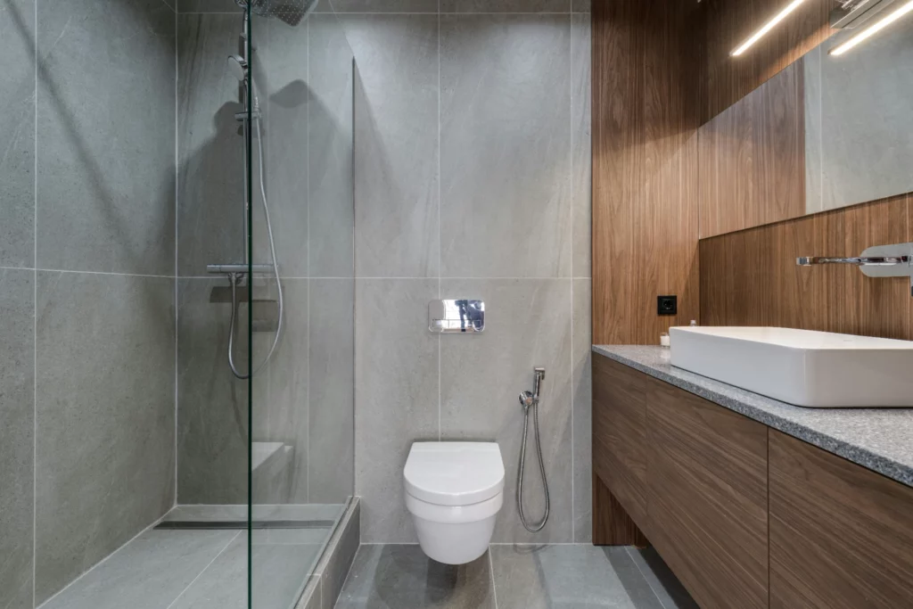 Salle de bain moderne avec douche et toilettes suspendues. - RenovSmart Salle de bain moderne avec douche en verre, toilettes suspendues et lavabo design en pierre.