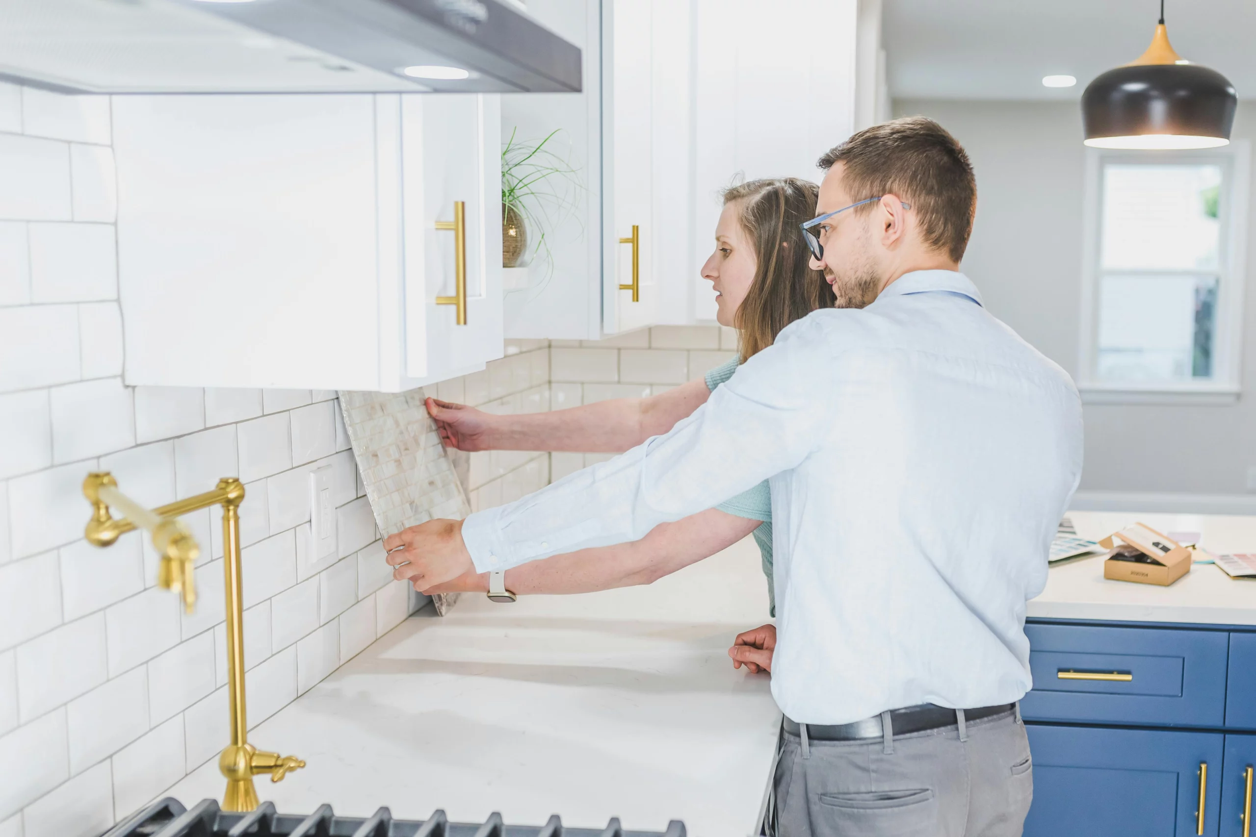 Couple choisissant un carrelage de crédence pour leur cuisine rénovée.