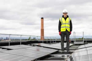 pexels-thisisengineering-19895867_optimized - RenovSmart Technicien en sécurité avec casque et gilet réfléchissant debout sur un toit équipé de panneaux solaires.