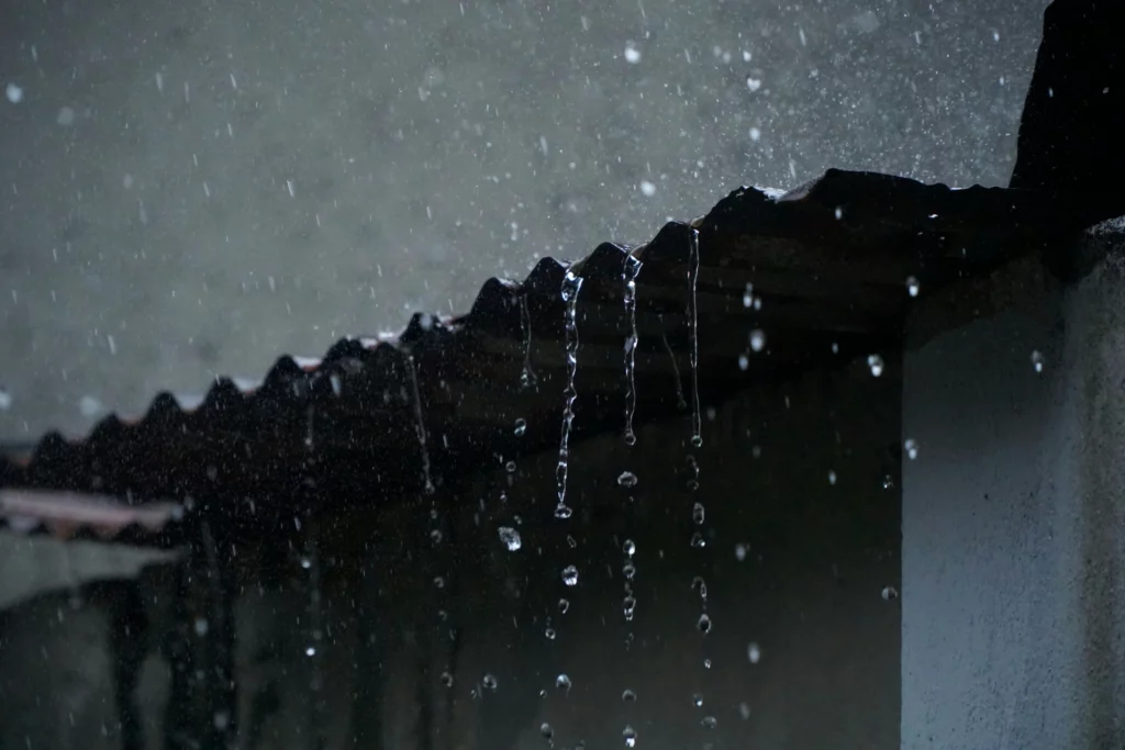 Gouttes de pluie tombant d'un toit en métal pendant une pluie.